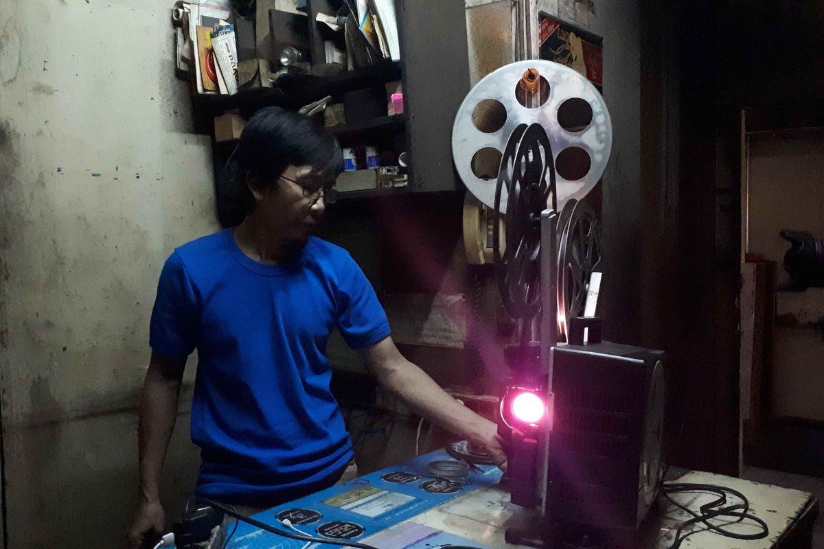 Danny Mulyana saat memutar film menggunakan proyektor analog di kamarnya di samping ruangan Grand 1, Bioskop Mulia Agung, Senen, Jakarta Pusat. Foto diambil Kamis (14/3/2019).