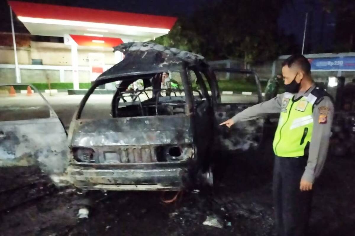 Seorang anggota polisi memerlihatkan kondisi mobil pikap pengangkut tabung gas elpiji 3 kg yang hangus terbakar di area sebuah SPBU di Warungkondang, Cianjur, Jawa Barat, Kamis (22/10/2020) malam.