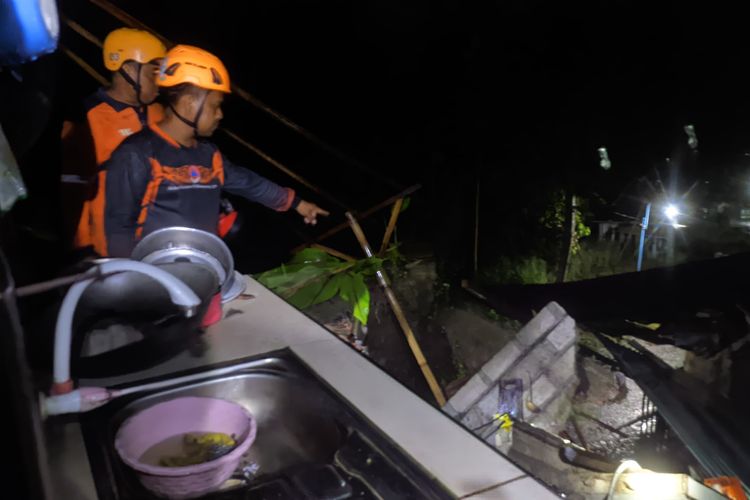 TANAH LONGSOR: Satu orang dilaporkan tewas setelah tanah longsor menimpa rumah warga di Desa Tileng, Kecamatan Dagangan Kabupaten Madiun, Jawa Timur, Sabtu (21/12/2024) petang. Petugas BPBD Madiun menunjukkan lokasi korban tersengat listrik saat hendak menyelamatkan barang usai rumah runtuh diterjang tanah longsor. 