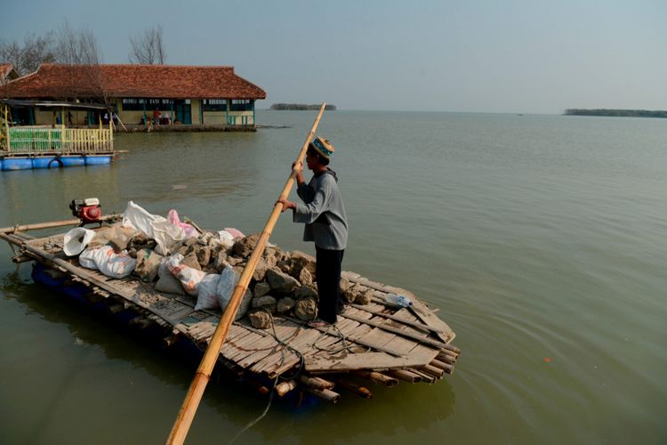 Warga membawa material untuk meninggikan rumah mereka dari ancaman terendam pasang air laut di Desa Bedono, Kecamatan Sayung, Kabupaten Demak, Jawa Tengah, Senin (30/7/2018). Abrasi, penurunan permukaan tanah hingga perubahan iklim membawa dampak besar terhadap persoalan pesisir di Jawa Tengah antara lain Pekalongan, Kendal, Kota Semarang dan Demak.

KOMPAS/P RADITYA MAHENDRA YASA (WEN)
30-07-2018