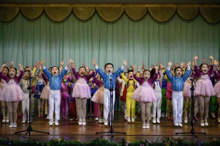 Murid-murid TK Kota Sinuiju di kota perbatasan Korea Utara, Sinuiju, tampil dalam pertunjukan selama satu jam, bertajuk Kami Tidak Bisa Hidup Tanpa Anda, Ayah, yang merujuk pada Kim Jong Un. Gambar ini diambil pada 1 Desember 2018. (AFP/Ed Jones)
