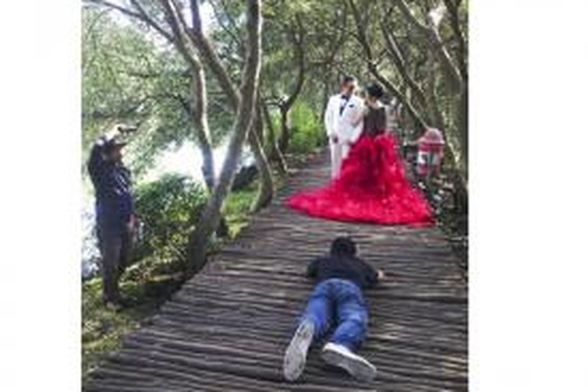 M Arief Erlangga, yang sambil telungkup, bersama krunya tengah mengambil gambar foto dari klien atau pelanggannya di kawasan Wisata Alam Mangrove, Pantai Indah Kapuk, Jakarta.