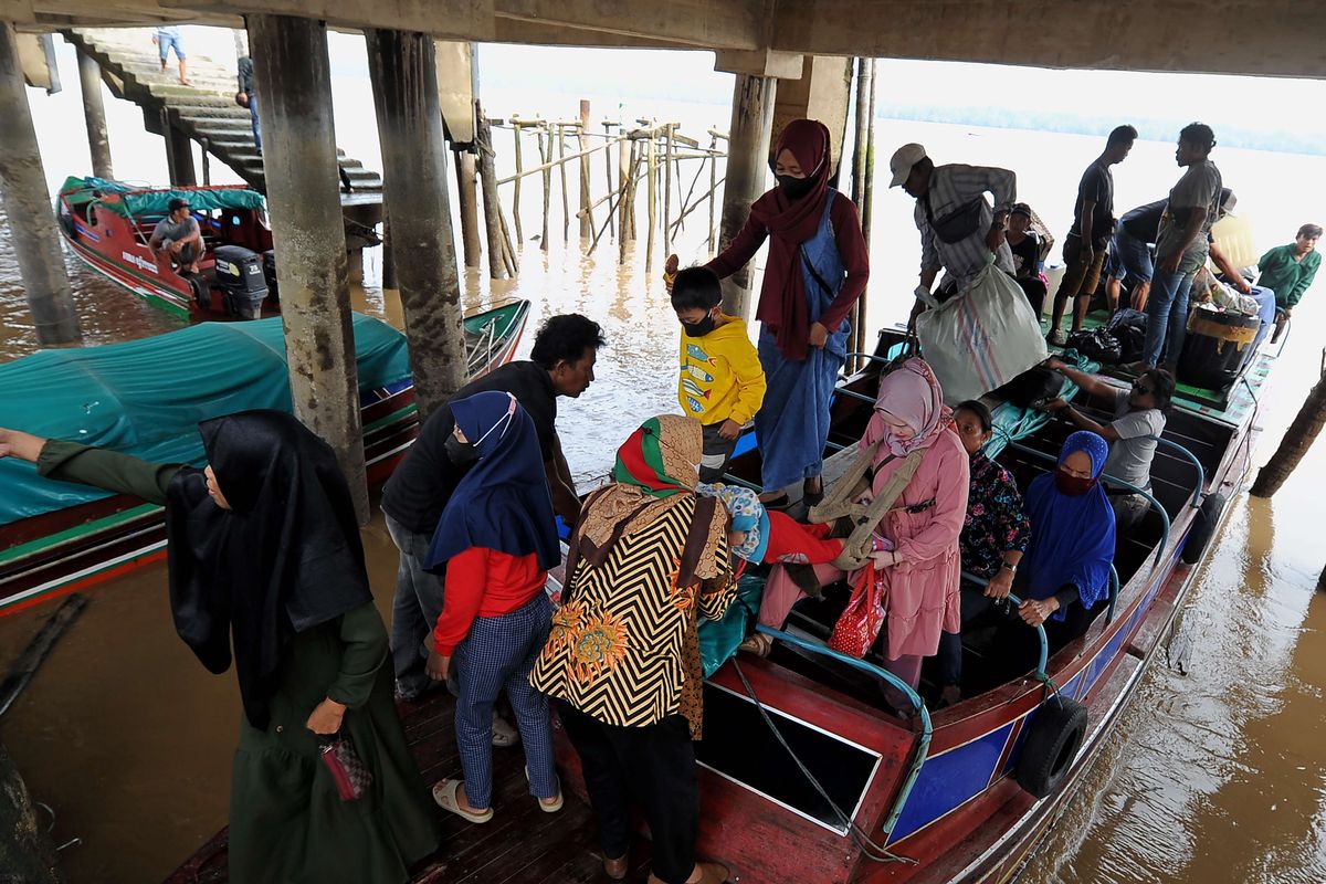 Pemudik bersiap keluar dari kapal cepat setibanya di dermaga Pelabuhan LLASDP Kuala Tungkal, Tanjungjabung Barat, Jambi, Minggu (17/4/2022). Sejumlah warga memilih untuk mudik lebih awal untuk menghindari terjadinya lonjakan penumpang dan kenaikan harga saat mendekati puncak arus mudik.