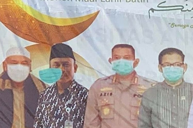 Perhatikan orang kedua dari kiri dalam foto itu. Masker tampak melayang di depan wajahnya. Orang kedua dalam foto itu adalah Kepala Kantor Kementerian Agama Kota Depok, Asnawi. Dalam foto aslinya, Asnawi memang tidak menggunakan masker.

