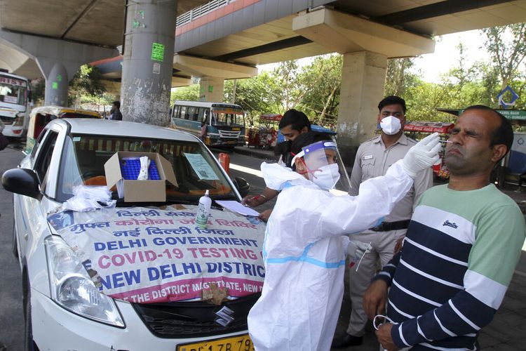 A man reacts as a health worker in protective suit takes his nasal swab sample to test for COVID-19 in New Delhi, India, Saturday, May 22, 2021. (AP Photo/Satish Sharma)