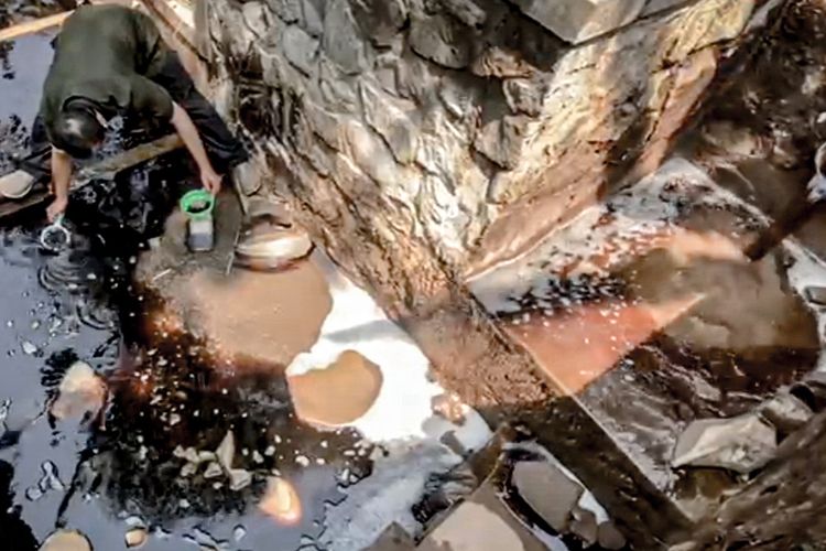 Aktivis lingkungan yang tergabung dalam Tim Masyarakat Peduli TPA Sarimukti melakukan pengambilan sampel air lindi di outfall IPAL TPA Sarimukti, Minggu (30/7/2023).