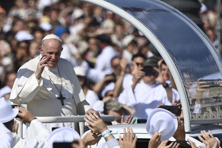 Paus Fransiskus menyapa umat beriman ketika ia tiba dengan kendaraan terbuka untuk Misa Kudus pada akhir Kongres Ekaristi Internasional di Budapest pada 12 September 2021, selama kunjungan kepausannya ke Hongaria.