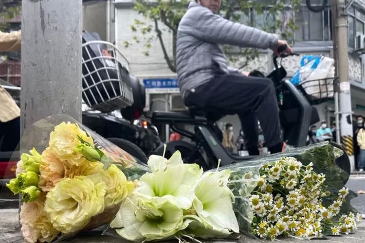 Khalayak meletakkan karangan bunga di Jalan Urumqi - namun polisi memungutinya.