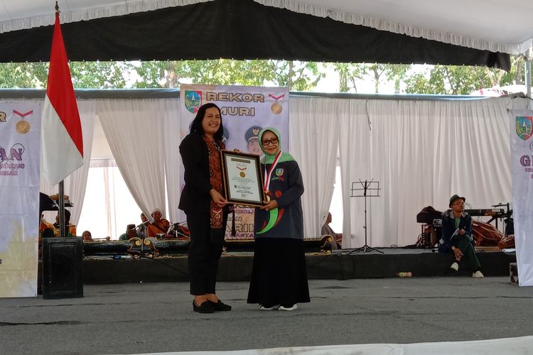 Perwakilan Muri Sri Widayati menyerahkan penghargaan Muri kepada Bupati Jombang Mundjidah Wahab, atas pemecahan rekor pada kegiatan makan nasi kikil bersama di alun-alun Kabupaten Jombang, Jawa Timur, Sabtu (23/9/2023).