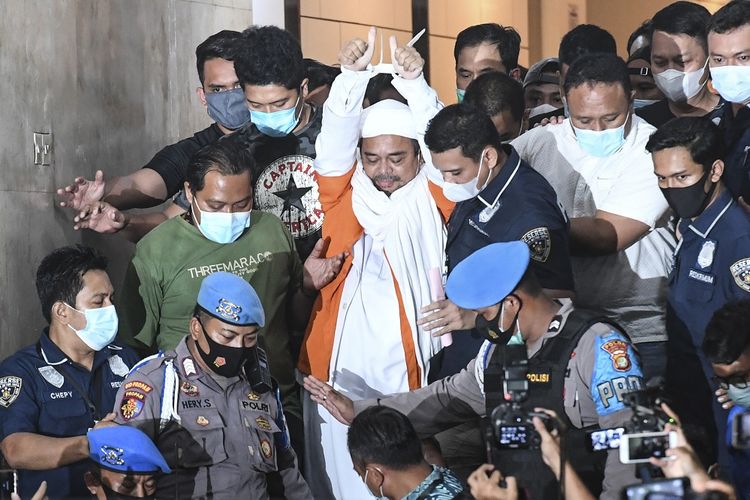 Imam Besar <a href='https://manado.tribunnews.com/tag/front-pembela-islam' title='Front Pembela Islam'>Front Pembela Islam</a> (FPI) <a href='https://manado.tribunnews.com/tag/habib-rizieq-shihab' title='Habib Rizieq Shihab'>Habib Rizieq Shihab</a> (tengah) berjalan menuju mobil tahanan usai diperiksa di Mapolda Metro Jaya, Jakarta, Minggu (13/12/2020) dini hari. Rizieq Shihab ditahan penyidik Ditreskrimum Polda Metro Jaya untuk kepentingan penyidikan perkara kasus dugaan pelanggaran protokol kesehatan COVID-19 terkait kerumunan di Petamburan, Tanah Abang, Jakarta pada 14 November lalu. ANTARA FOTO/Hafidz Mubarak A/pras.