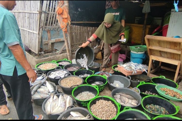 Sri Suraningsih, salah satu pedagang di pasar ikan gebang, Kabupaten Cirebon melayani pembeli, Rabu (28/12/2022). Sri sebut harga ikan naik drastis imbas cuaca buruk dan juga momen Natal dan tahun baru.