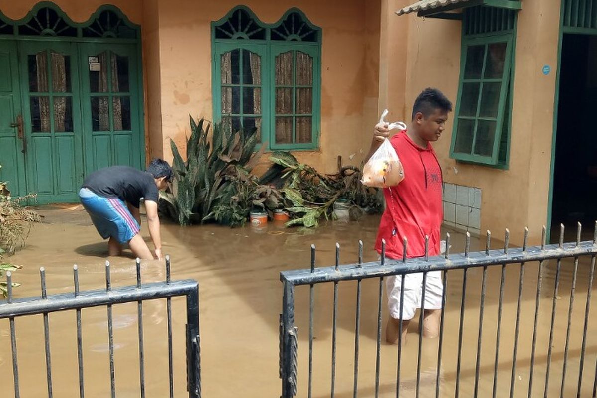 Surutnya banjir di kawasan Ciledug Indah 1, Kecamatan Ciledug, Kota Tangerang, Jumat (3/1/2020), dimanfaatkan warga setempat untuk berburu ikan.  
