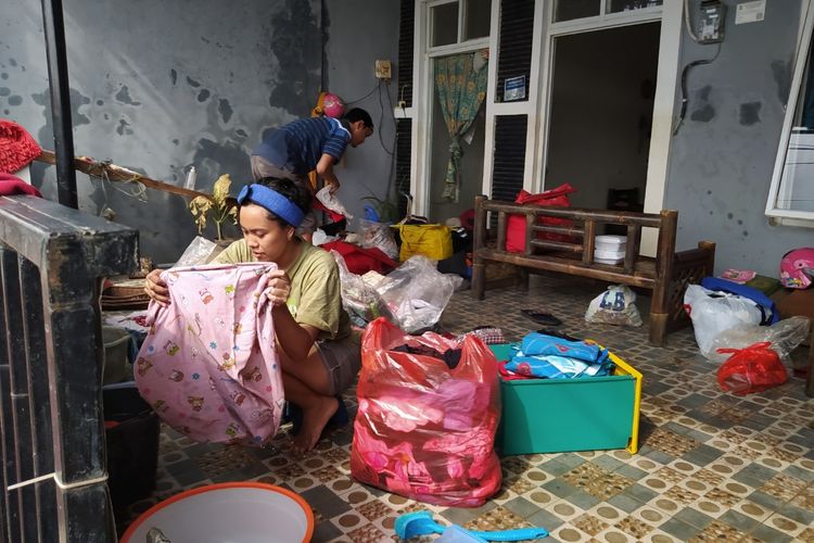 La Muhammad Deni dan Kartika, sepasang suami istri yang tinggal di RW 025 Kelurahan Gebang Raya, Kecamatan Periuk, Kota Tangerang, Banten yang sedang membereskan rumah pada Jumat (26/2/2021), usai kediamannya direndam banjir selama enam hari sejak Sabtu pekan lalu. Akibat terendam banjir, pasangan suami istri itu merugi hingga belasan juta.