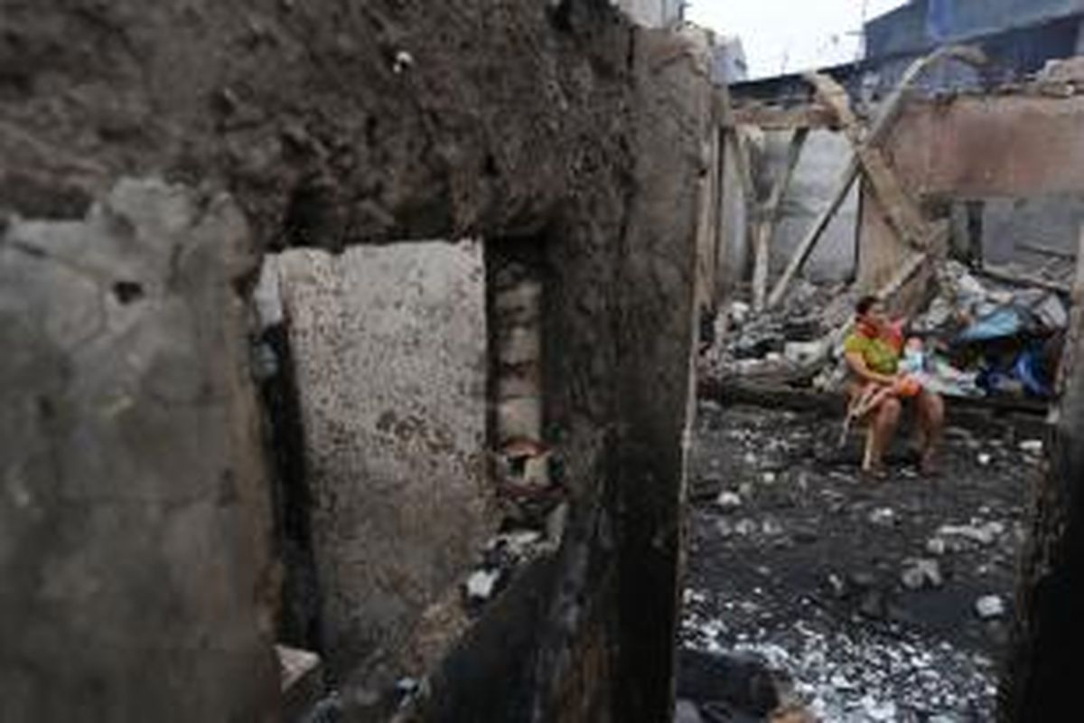 Warga korban kebakaran di Tambora, Jakarta Barat, duduk di kawasan rumahnya yang telah hangus, Minggu (27/9/2015).