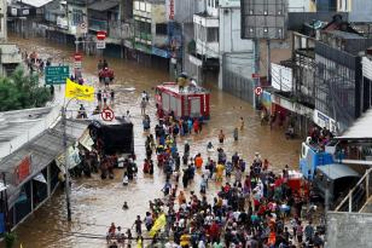 Jalan Jatinegara Barat terendam banjir luapan Kali Ciliwung, Jakarta, Sabtu (18/1/2014). Hujan dengan intensitas lebat disertai angin diperkirakan masih akan terus terjadi di Jakarta dan sekitarnya hingga Senin ((20/1/2014) mendatang. KOMPAS IMAGES/KRISTIANTO PURNOMO