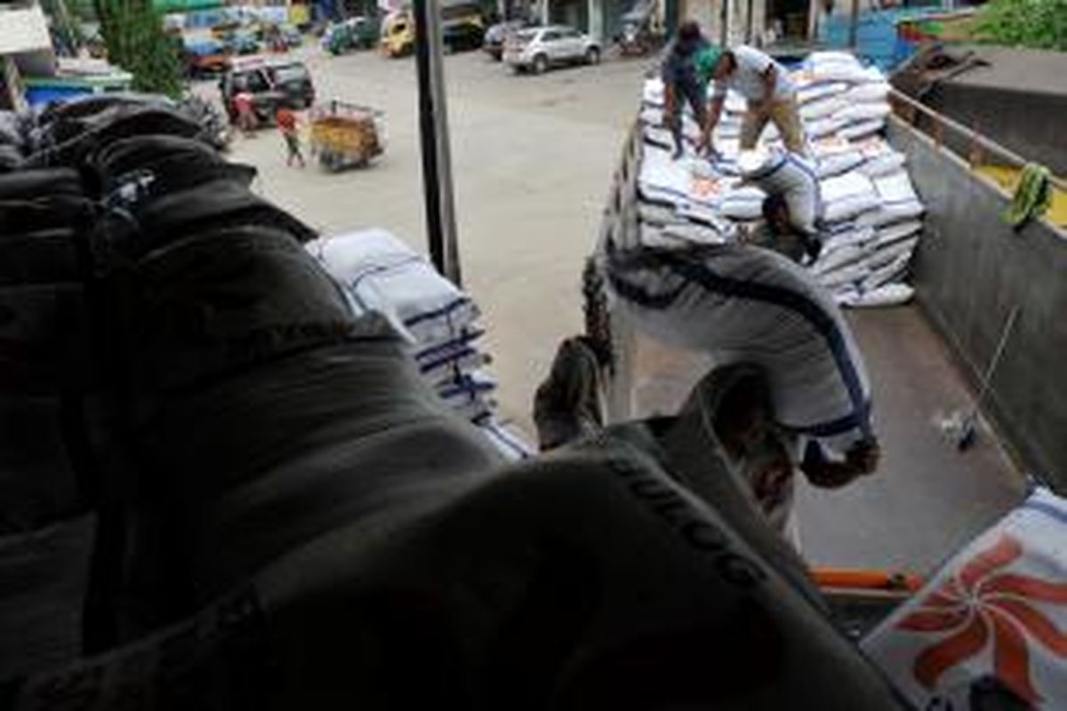 Buruh menurunkan beras bulog dari truk ke salah satu kios di Pasar Induk Beras Cipinang, Jakarta, Selasa (11/12/2012). Beras-beras tersebut digelontorkan ke pasar sebagai langkah operasi stabilisasi harga beras (OSHB) menjelang Natal dan tahun baru. Bulig mematok harga eceran tertinggi beras tersebut Rp 7.400 per kilogram.