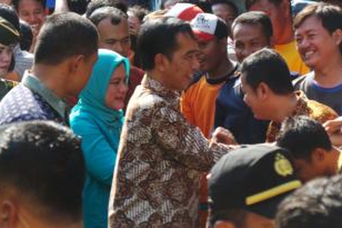 Presiden Joko Widodo bersama Ibu Negara Iriana Joko Widodo saat membagikan sembako di Kelurahan Kali Anyar, Kecamatan Tambora, Jakarta Barat, Selasa (1/9/2015).
