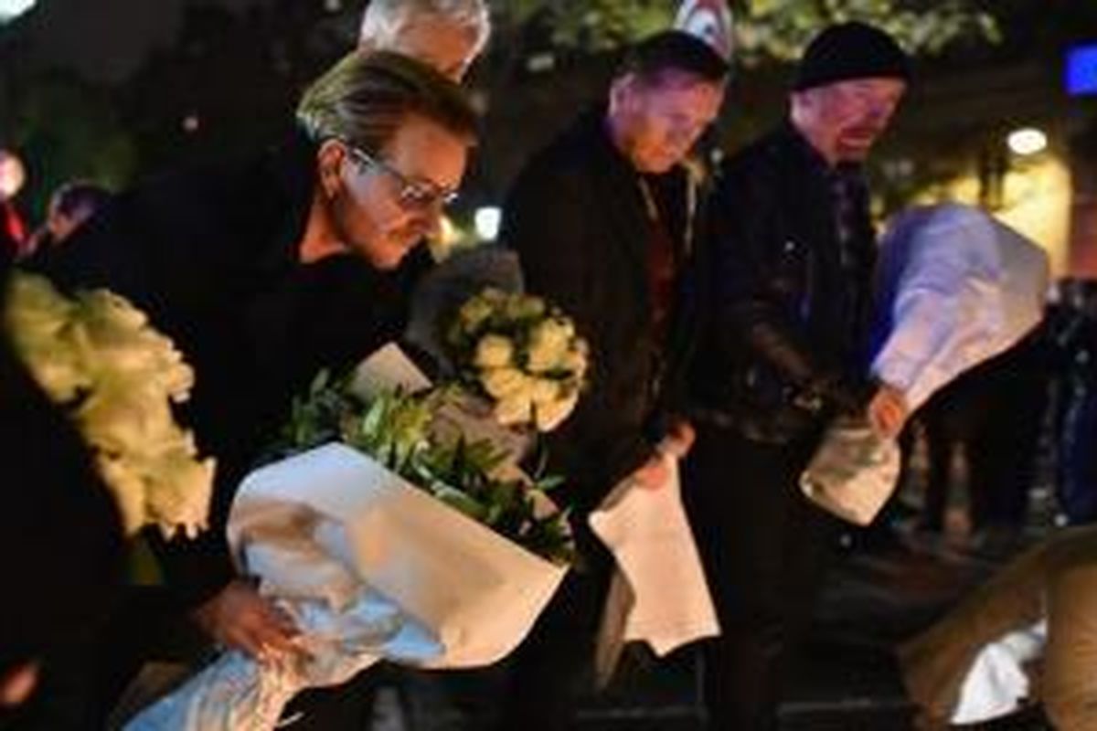 Vokalis band U2, Bono, meletakkan karangan bunga di Bataclan Theatre, Paris, Perancis, Sabtu (14/11/2015). Bono menyatakan turut berduka atas serangan teroris yang menewaskan 153 korban jiwa dan ratusan korban luka lainnya pada Jumat (13/11/2015).