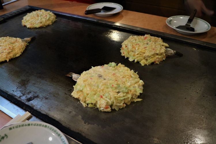Proses memanggang okonomiyaki setelah semua adonan dituang, Sabtu (21/1/2023).