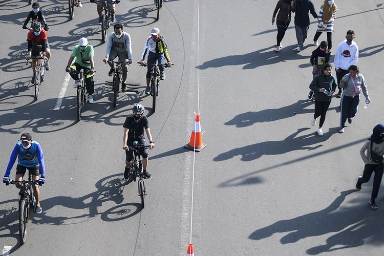 Warga berolahraga saat hari bebas berkendara atau car free day (CFD) di kawasan Jalan MH Thamrin, Jakarta, Minggu (21/6/2020). Dinas Perhubungan (Dishub) Provinsi DKI Jakarta memisahkan jalur untuk pesepeda, olahraga lari, dan jalan kaki saat CFD pertama pada masa pembatasan sosial berskala besar (PSBB) transisi.