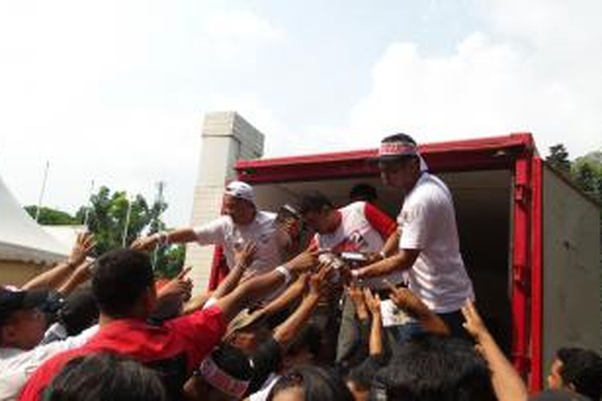 Relawan Jokowi saat membagi-bagikan buku, jelang konser Salam 2 Jari, di Stadion Gelora Bung Karno, Sabtu (5/7/2014)