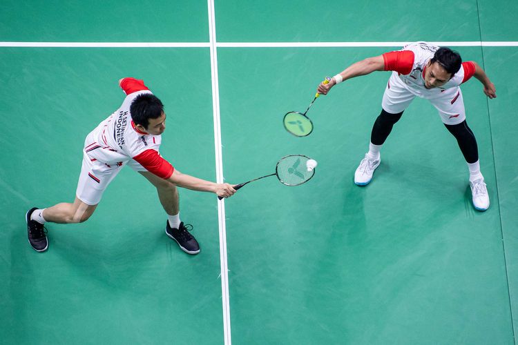 Pemain ganda putra Indonesia  Mohammad Ahsan (kanan) dan Hendra Setiawan (kiri) mengembalikan kok ke arah lawannya pebulu tangkis ganda putra Thailand Chaloempon Charoenkitamorn dan Nanthakarn Yordphaisong dalam pertandingan babak penyisihan grup A Piala Thomas Uber 2022 di Impact Arena, Bangkok, Thailand, Senin (9/5/2022). Hendra/Ahsan kalahkan ganda putra Thailand dengan skor 21-12, 26-28 dan 21-11.