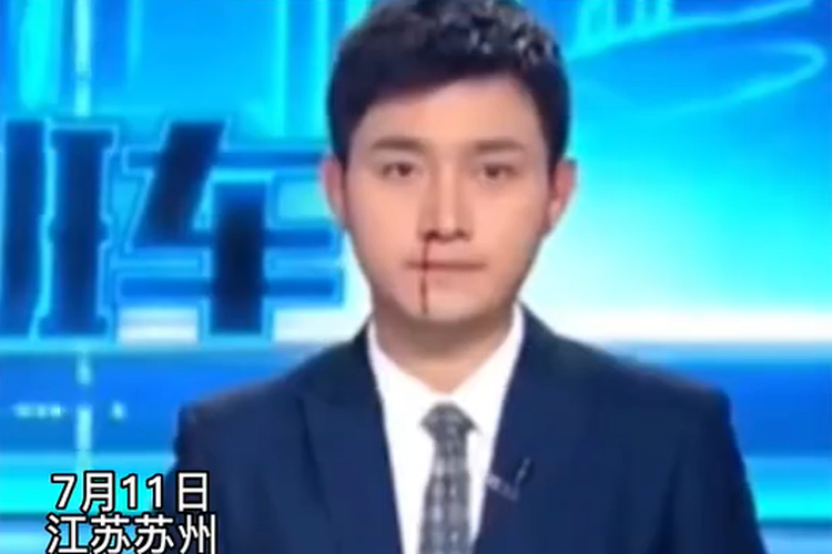 Tangkap layar pembaca berita Huang Xinqi dengan tenang terus membaca buletin berita hari itu, sementara darah mengalir di hidungnya.
