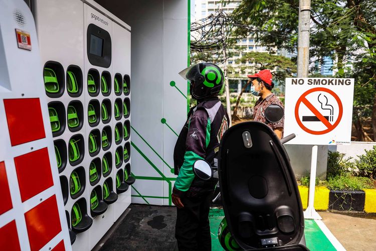 Pengemudi ojek daring mengganti baterai sepeda motor listrik dengan yang sudah penuh terisi di Stasiun Penukaran Baterai Kendaraan Listrik Umum (SPBKLU) di SPBU Pertamina, Jalan MT Haryono, Jakarta, Senin (28/3/2022). Pemerintah Indonesia menargetkan dua juta kendaraan listrik dapat digunakan oleh masyarakat Indonesia pada 2025 sebagai salah satu upaya untuk menerapkan penggunaan energi terbarukan.