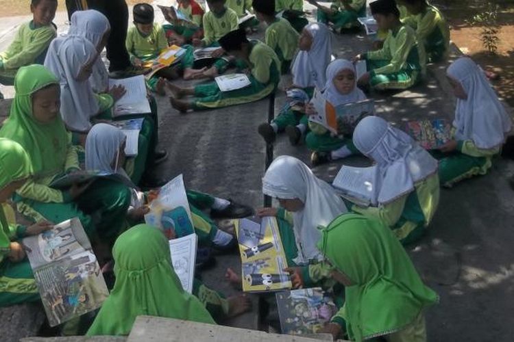 Sejumlah siswa MIN Sumurejo, Kecamatan Gunung Pati, Kota Semarang, membaca buku di sela waktu istirahat di halaman sekolah.