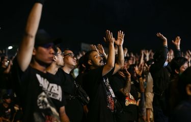 Penontong menyaksikan aksi pangggung grup band heavy metal Trivium di panggung Hammersonic Festival 2023 di Pantai Carnaval Ancol, Jakarta Utara,  Minggu (19/3/2023). Vokalis Trivium, Matthew Kiichi Heafy mengenakan batik dan jersey Timnas Indonesia saat tampil di Hammersonic 2023.