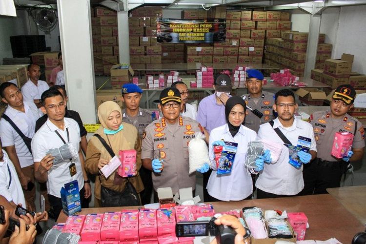 Petugas Kepolisian Resor Kota Sidoarjo Jawa Timur menujukkan barang bukti masker ilegal di salah satu pergudangan di Sidoarjo , Jawa Timur.