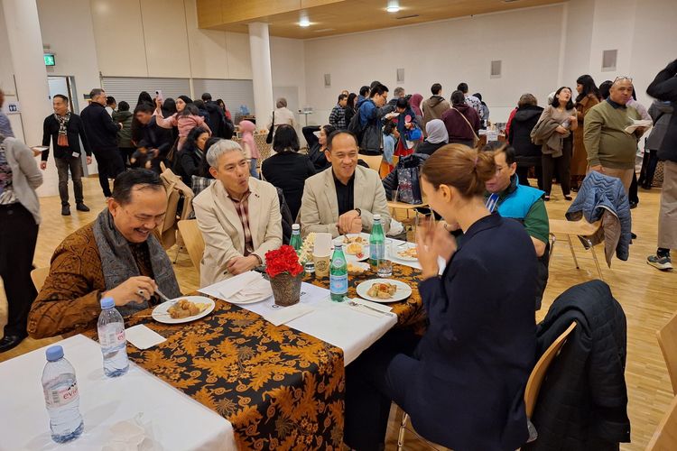Sejumlah WNI dan warga setempat menyantap hidangan yang disediakan bazar makanan di TPS Mattenhofsaal, Guemligen, desa di pinggiran Kota Bern, Swiss, Sabtu (10/2/2024), saat pemungutan suara pemilu Indonesia 2024 digelar.