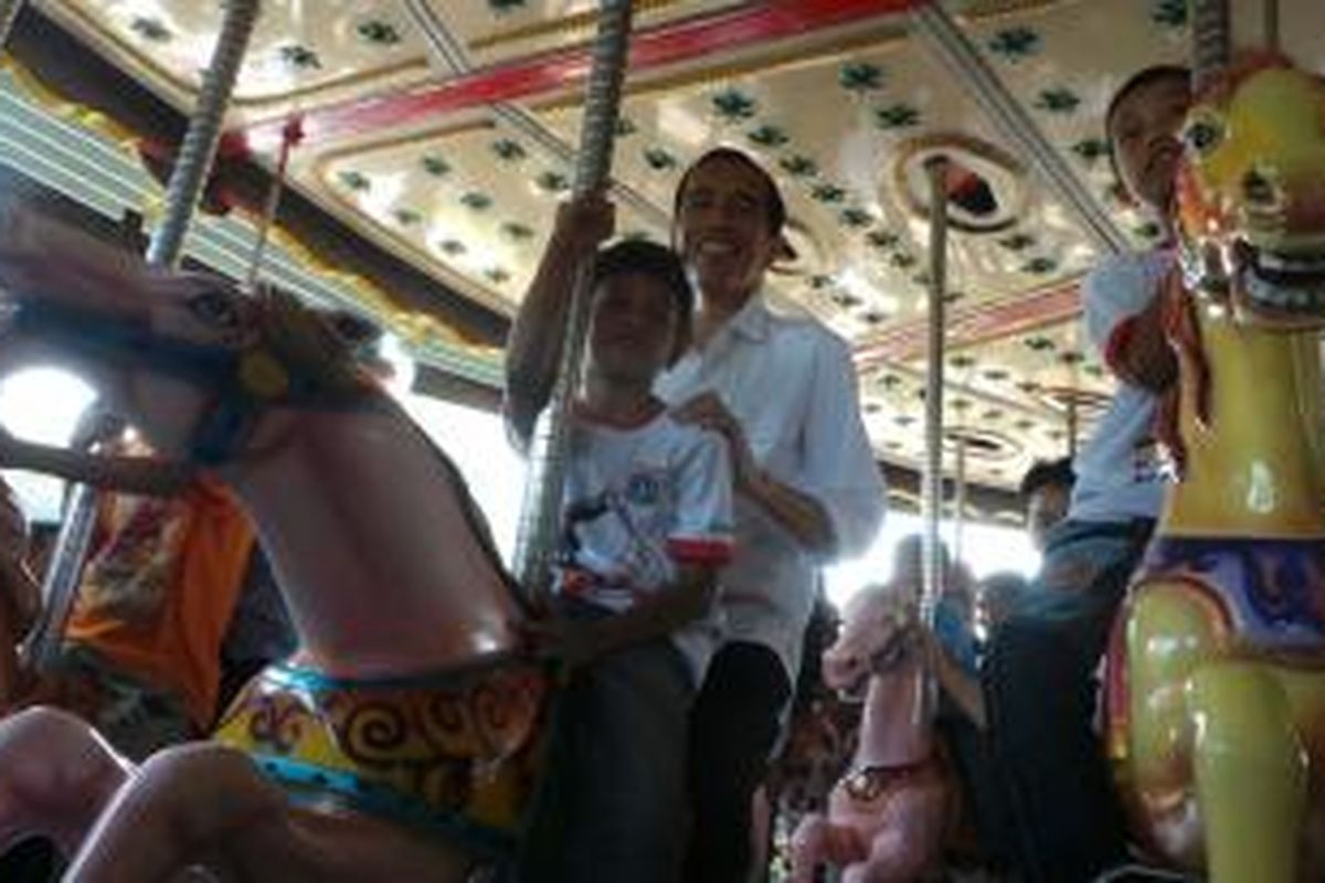 Gubernur DKI Jakarta Joko Widodo Jokowi menaiki komedi putar di Dufan. Dia hadir untuk mengikuti acara Hari Anak Nasional tingkat provinsi di Dufan, Taman Impian Jaya Ancol, Jakarta Utara, Kamis (22/8/2013). 