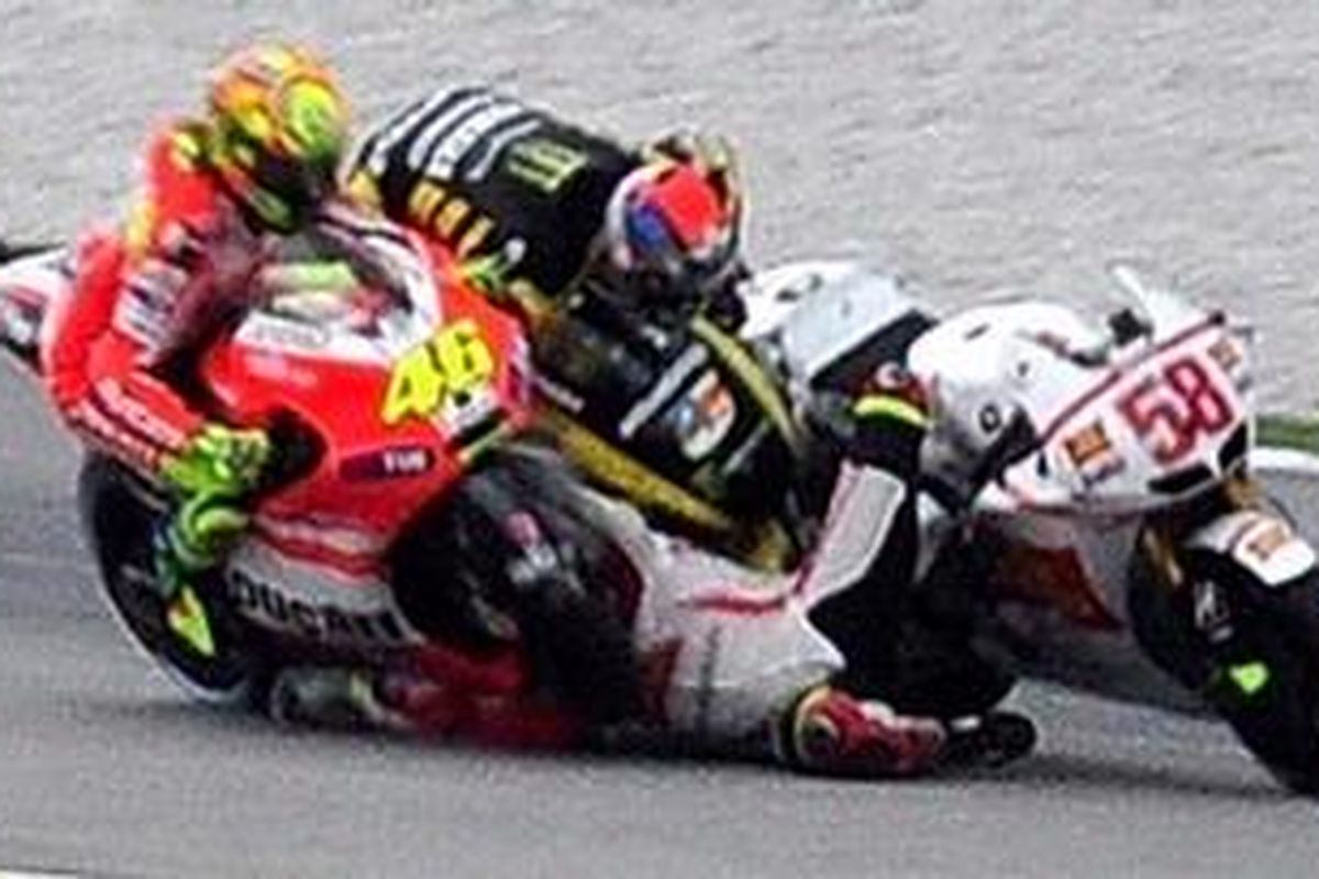 Pebalap Ducati, Valentino Rossi (kiri), ikut tersenggol ketika motor pebalap Gresini Honda, Marco Simoncelli (tengah), jatuh, dan ditabrak motor pebalap Yamaha Tech 3, Colin Edwards (atas), di Tikungan 11 lap kedua GP Malaysia, Minggu (23/10). Akibat tabrakan ini, helm Simoncelli terlepas dan dia langsung terkapar di lintasan, dan kemudian dinyatakan meninggal dunia. Sedangkan Edwards mengalami dislokasi bahu, dan Rossi selamat dari kecelakaan maut ini.