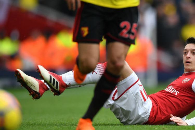Gelandang Arsenal, Mesut Oezil, terjatuh saat melawan Watford pada pertandingan Liga Inggris di Stadion Emirates, London, Minggu (11/3/2018).