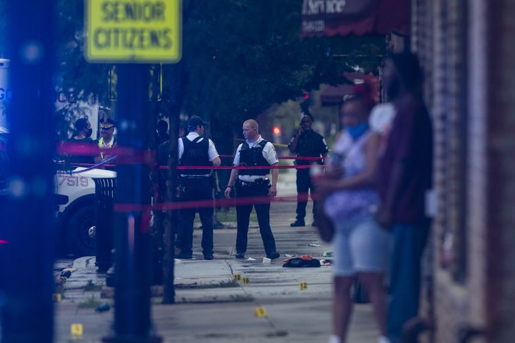 Polisi Chicago menyelidiki lokasi penembakan massal di mana lebih dari selusin orang ditembak di lingkungan Gresham, Chicago, pada Selasa, 21 Juli 2020.