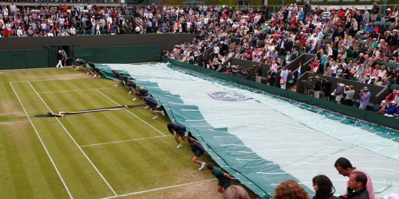 Para petugas lapangan menarik penutup untuk melindungi Court 3 dari hujan yang turun di tengah pertandingan antara Grigor Dimitrov dari Bulgaria dan Grega Zemlja dari Slovenia, pada babak kedua turnamen grand slam Wimbledon, Kamis (27/6/2013).