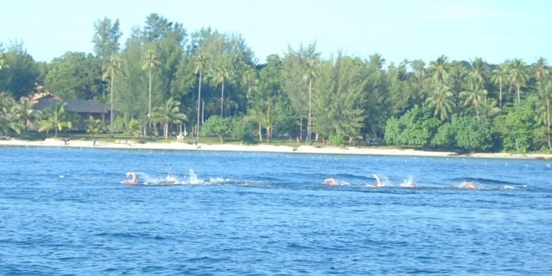 Dengan latar pemandangan pantai yang indah, para triatlet berenang mengitari pantai Bintan pada MetaMan Bintan Triathlon 2013 di Riau, Sabtu (31/8/2013). 