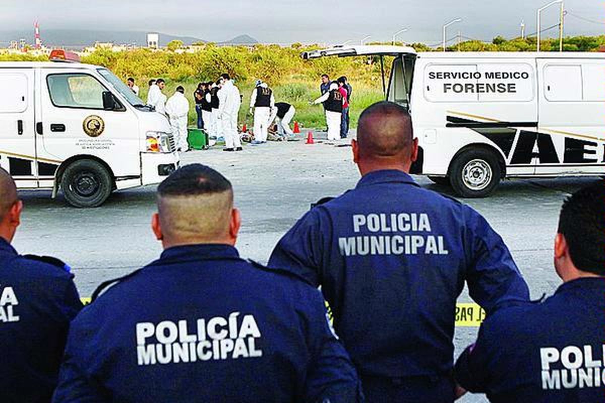 Polisi mengamati tim forensik yang sedang memeriksa korban pembantaian dalam perang narkoba di pinggiran kota Monterrey, Meksiko, Rabu (16/6). 