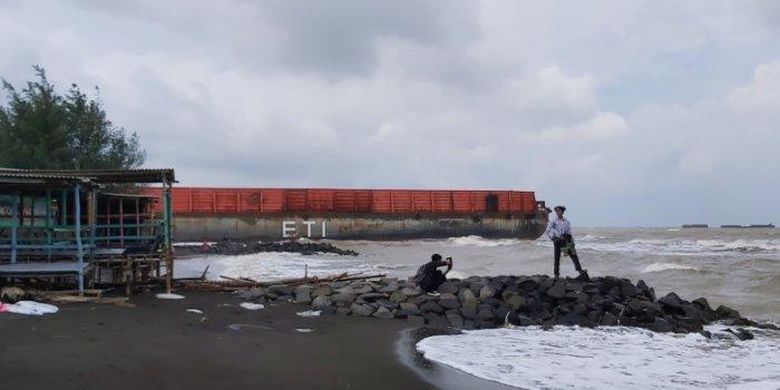 
Kapal tongkang pengangkut batu bara terdampar di area Objek Wisata Pantai Pulau Kodok, Kota Tegal, Senin (18/1/2021).
