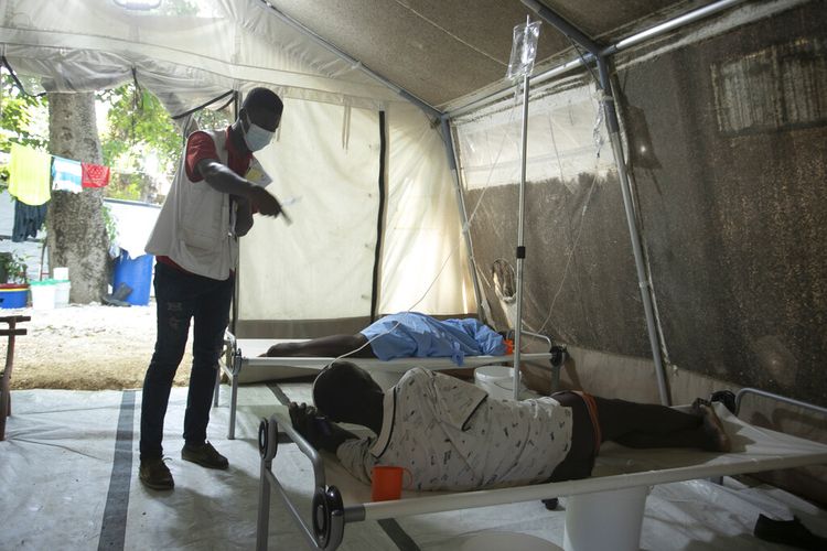 Seorang pekerja di Doctors Without Borders (MSF) memberikan instruksi kepada seorang pasien yang menderita gejala kolera di klinik MSF di Port-au-Prince, Haiti, Jumat, 7 Oktober 2022.