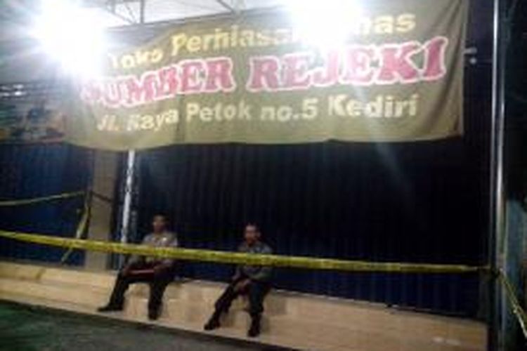 Dua personil polisi menjaga toko emas yang baru saja distaroni perampok di Jalan Raya Petok, Desa Petok, Kecamatan Mojo, Kabupaten Kediri, Jum'at (14/3/2014).