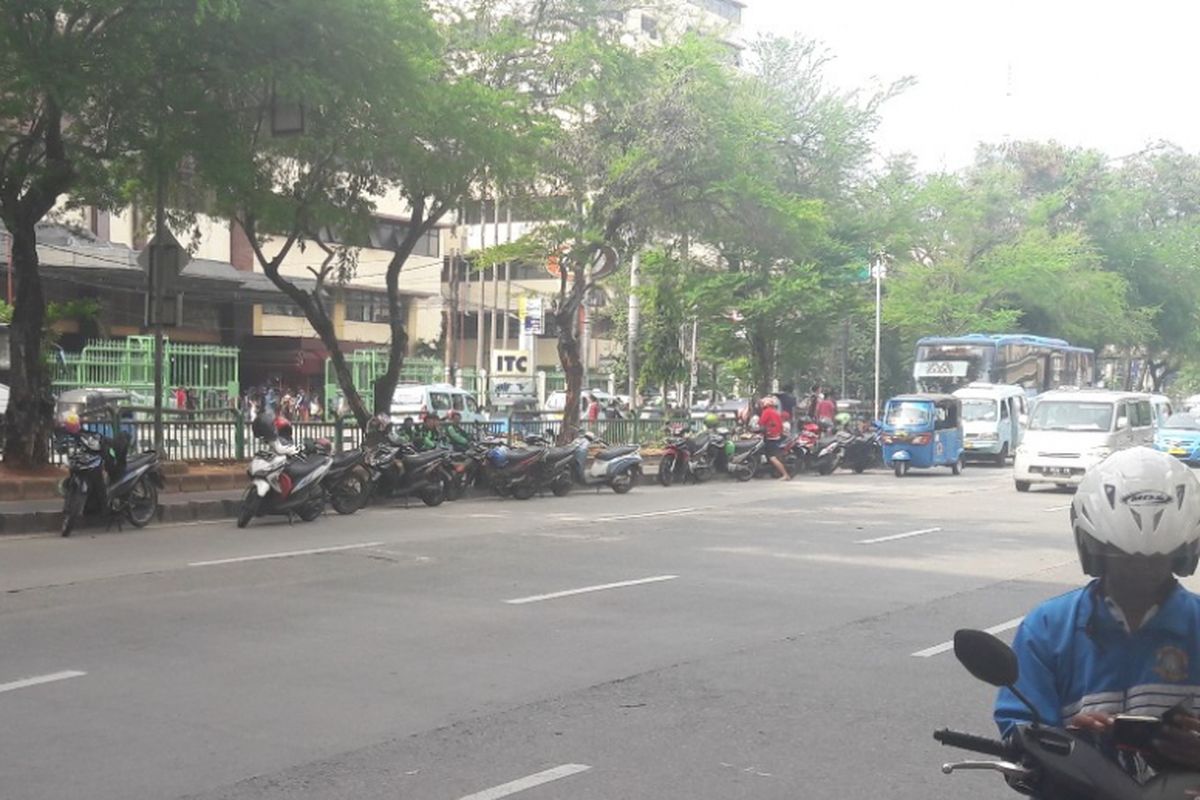 Sejumlah sepeda motor milik pengemudi ojek online diparkir di tepian jaur Transjakarta di Mangga Dua, Jakarta Utara, Minggu (15/4/2018).