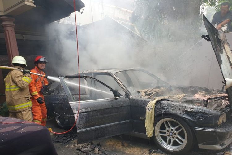 etugas Suku Dinas Penanggulangan Kebakaran dan Penyelamatan Jakarta Timur memadamkan api yang bersumber dari korsleting listrik pada bagian mesin mobil sedan di Balekembang, Kramat Jati, Jakarta Timur, Senin (16/3/2020). 