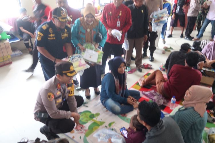 Petugas saat memberikan bantuan kepada penumpang yang tertahan di Pelabuhan Kalianget Sumenep, Jumat (30/12/2022). 