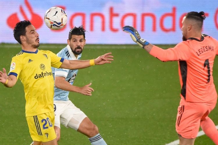 Bek Spanyol Cadiz Iza Carcelen (kiri) bersaing dengan penyerang Spanyol Celta Vigo Nolito di samping kiper Argentina Cadiz Jeremias Ledesma selama pertandingan sepak bola liga Spanyol RC Celta de Vigo melawan Cadiz CF di stadion Balaidos di Vigo pada 14 Desember 2020.