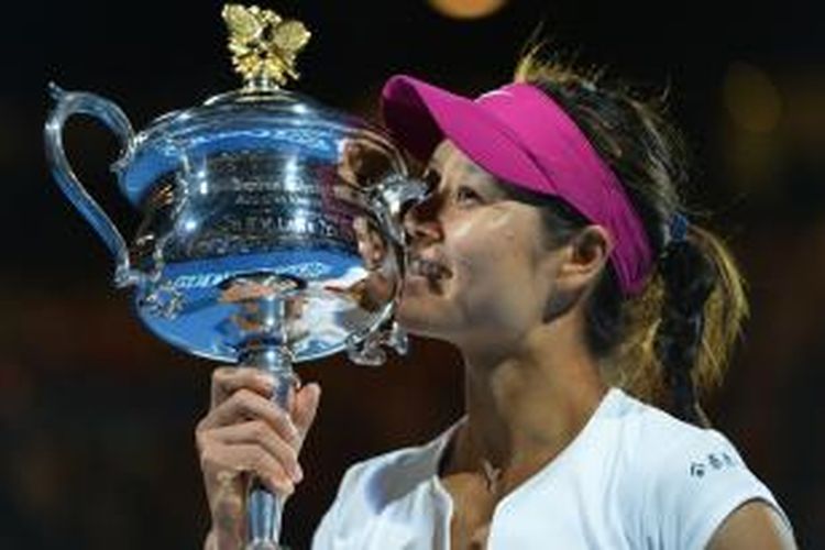 Petenis Tiongkok, Li Na, mencium trofi juara Australia Terbuka setelah mengalahkan petenis Slovakia, Dominika Cibulkova, pada laga final di Melbourne Park, Sabtu (25/1/2014).