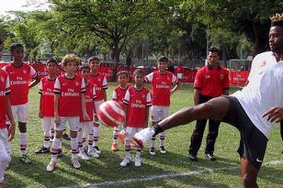 Gelandang Arsenal, Alex Song (kanan), membagi ilmu sepak bola kepada anak-anak, di Kuala Lumpur, 23 Juli 2012. 