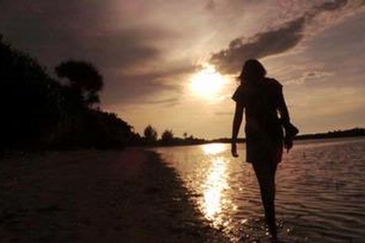 Seorang wanita wisatawan tengah berjalan di salah satu sudut Pantai Pasir Perawan, Kepulauan Seribu.