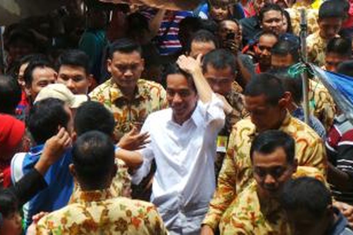 Presiden Joko Widodo menyalami warga dan pedagang saat ia meninjau Pasar Pagi Rawamangun, Jakarta Timur, Sabtu (28/2/2015).